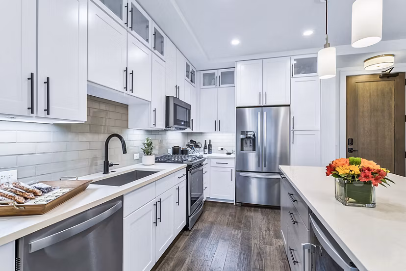 Sleek kitchen with white cabinets and stainless steel appliances at Parq on Speer Apartments in luxury Denver high-rise