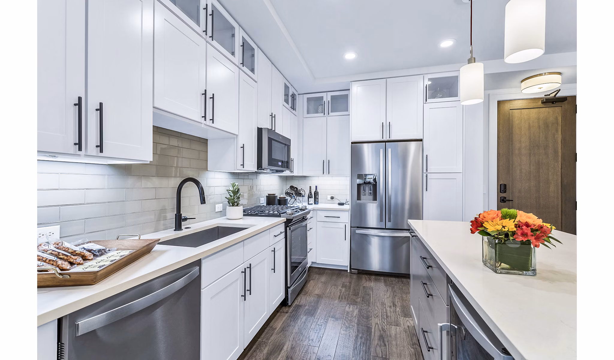 Sleek kitchen with white cabinets and stainless steel appliances at Parq on Speer Apartments in luxury Denver high-rise