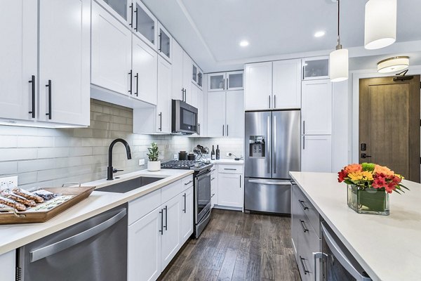Sleek kitchen with white cabinets and stainless steel appliances at Parq on Speer Apartments in luxury Denver high-rise