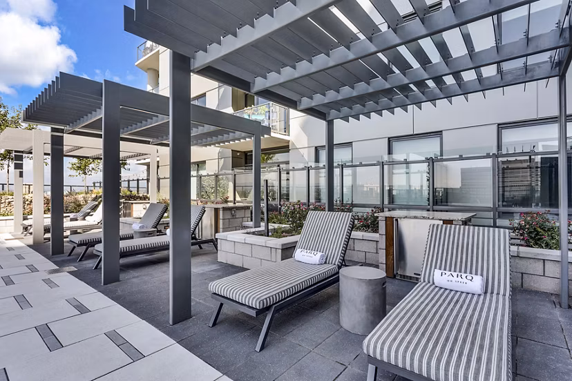 Outdoor lounge area with striped chairs and pergolas at Parq on Speer luxury apartments in downtown Denver