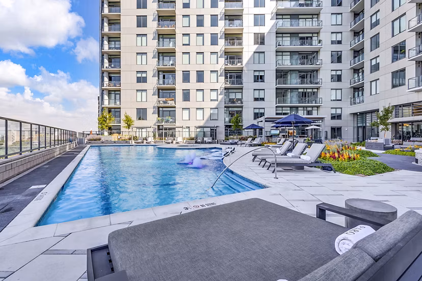 Outdoor pool area with lounge chairs at Parq on Speer Apartments in Denver, luxury modern living by Greystar