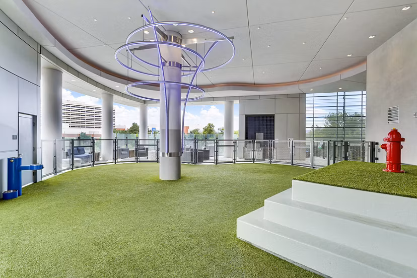 Indoor dog park with artificial grass and vibrant fixtures at Parq on Speer Apartments, luxury living by Greystar in downtown Denver