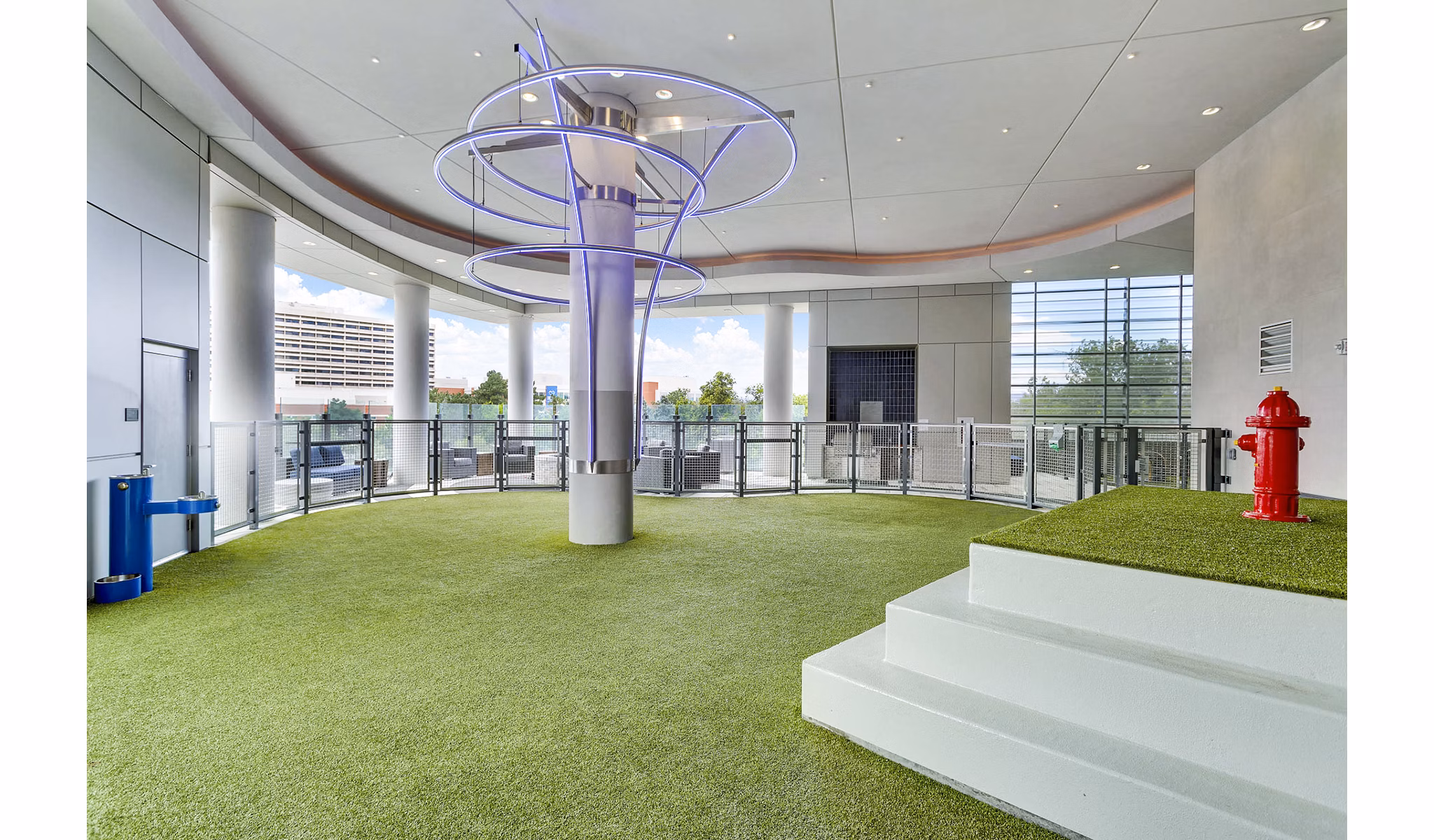 Indoor dog park with artificial grass and vibrant fixtures at Parq on Speer Apartments, luxury living by Greystar in downtown Denver