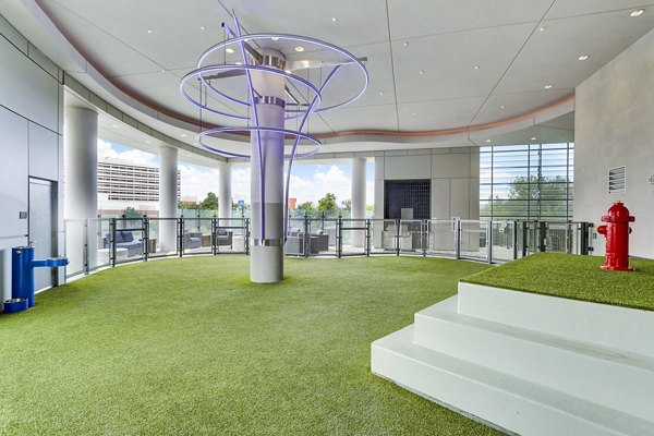 Indoor dog park with artificial grass and vibrant fixtures at Parq on Speer Apartments, luxury living by Greystar in downtown Denver