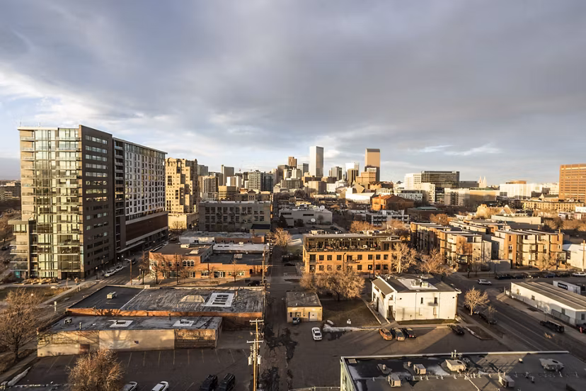 Parq on Speer Apartments: Aerial cityscape view with buildings under cloudy sky, highlighting luxury urban living in downtown Denver