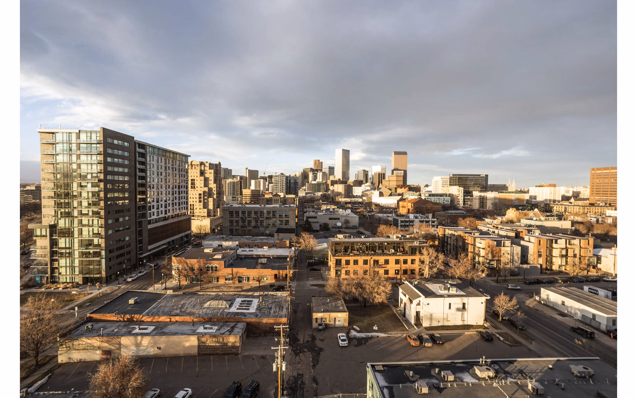 Parq on Speer Apartments: Aerial cityscape view with buildings under cloudy sky, highlighting luxury urban living in downtown Denver