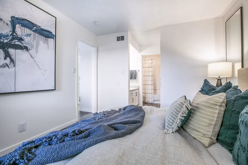 Aya ABQ Apartments: Modern bedroom featuring stylish furniture and natural lighting