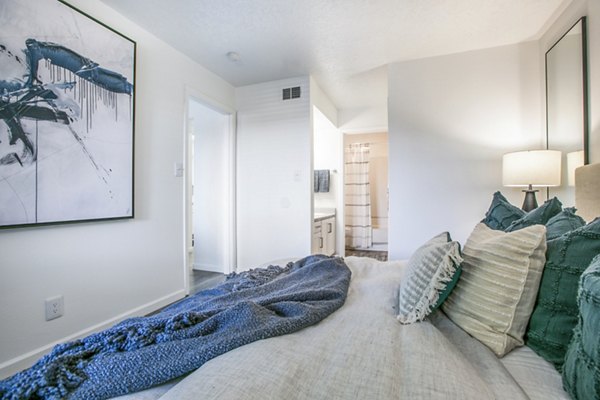 Aya ABQ Apartments: Modern bedroom featuring stylish furniture and natural lighting