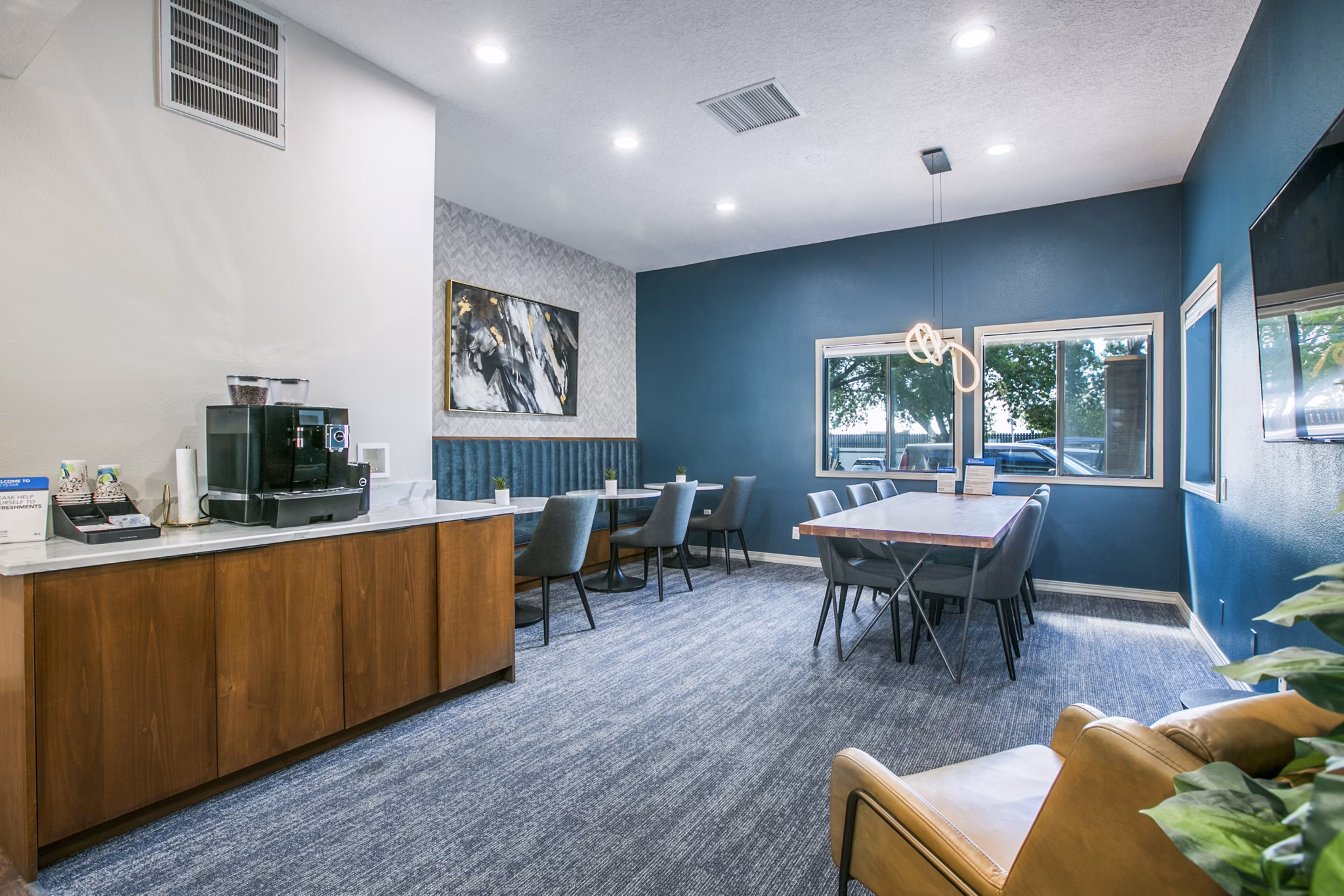 Elegant lobby with modern design at AYA ABQ Apartments featuring comfortable seating and stylish lighting fixtures, ideal for relaxation and socializing