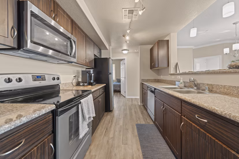 Modern kitchen with sleek countertops and stainless steel appliances at Bella Mirage Apartments