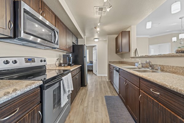 Modern kitchen with sleek countertops and stainless steel appliances at Bella Mirage Apartments