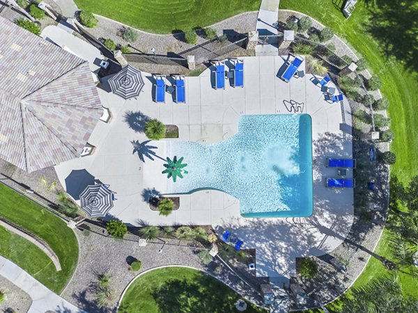 Resort-style pool surrounded by palm trees at Bella Mirage Apartments, perfect for relaxation and leisure