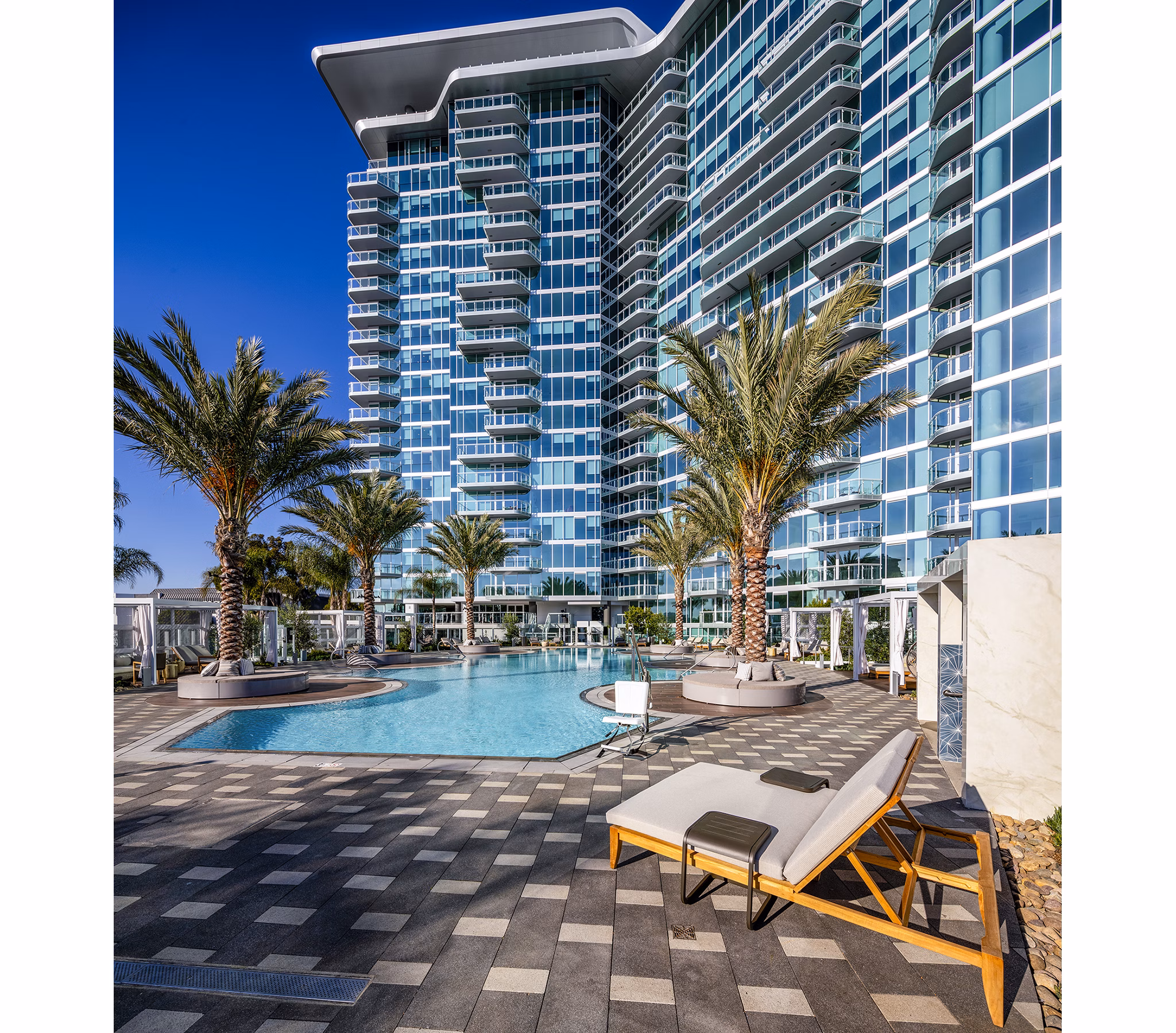 Luxurious pool area with surrounding palm trees at Palisade at Westfield UTC Apartments, perfect for leisure and relaxation
