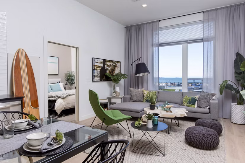 Spacious living room featuring modern decor and large windows in 500 Ocean Ave Apartments