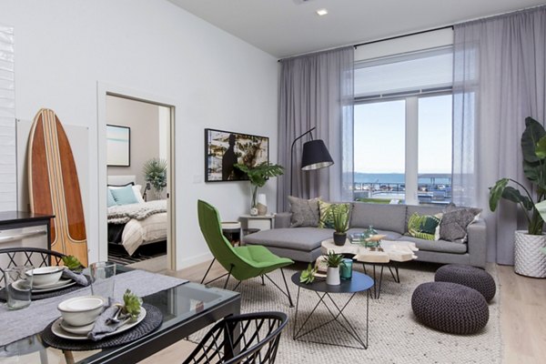 Spacious living room featuring modern decor and large windows in 500 Ocean Ave Apartments