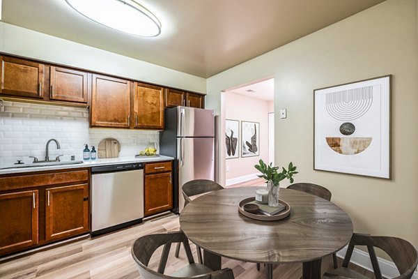 Kitchen and dining area with modern appliances and hardwood floors at Poplar Glen Apartments
