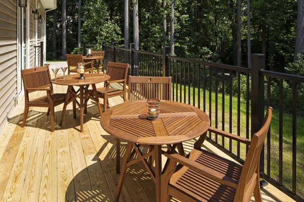 Private patio balcony with stylish outdoor seating at Poplar Glen Apartments in a tranquil garden setting