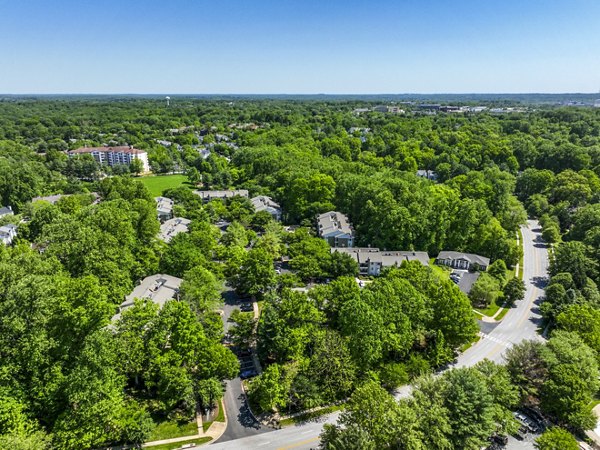 Aerial view of luxurious apartments surrounded by lush greenery in a serene residential neighborhood