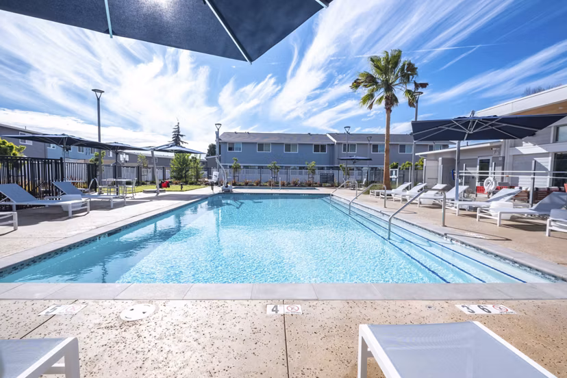 Resort-style pool with lush landscaping at Admirals Cove Apartments, offering luxury living and relaxation for residents