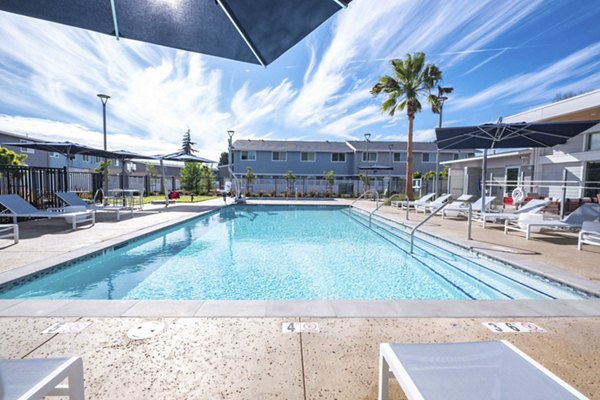 Resort-style pool with lush landscaping at Admirals Cove Apartments, offering luxury living and relaxation for residents