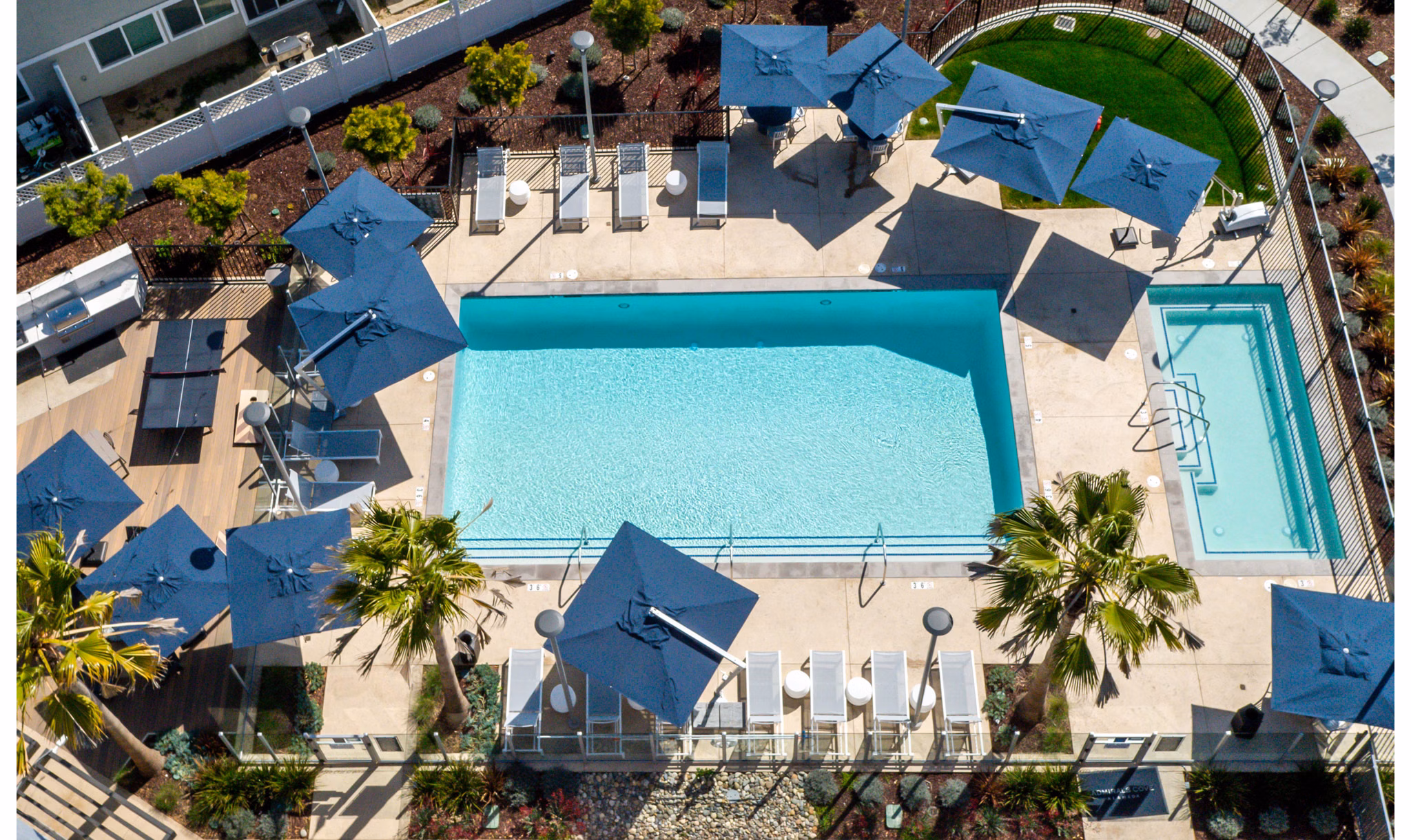 Outdoor pool with lounge chairs at Admirals Cove Apartments offering luxury swimming facilities and relaxation area