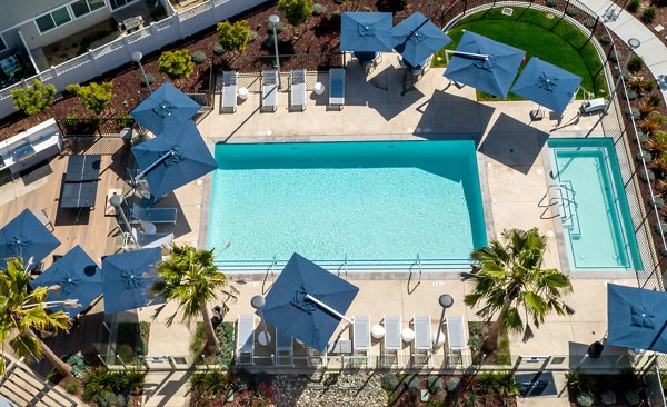 Outdoor pool with lounge chairs at Admirals Cove Apartments offering luxury swimming facilities and relaxation area
