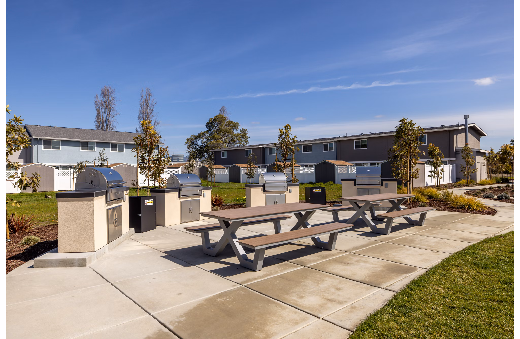 Modern grill area with seating and greenery at Admirals Cove Apartments, perfect for outdoor gatherings