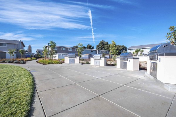 Outdoor grill area with modern seating at Admirals Cove Apartments, promoting community gatherings and leisure activities