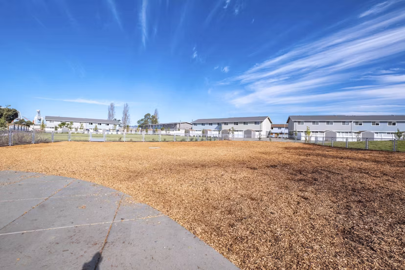 Pet-friendly dog park at Admirals Cove Apartments featuring agility equipment and open play area
