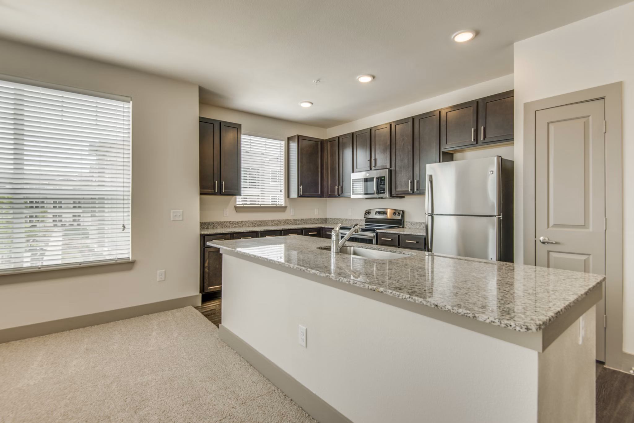 Modern kitchen with stainless steel appliances and granite countertops at The Grayson Apartments