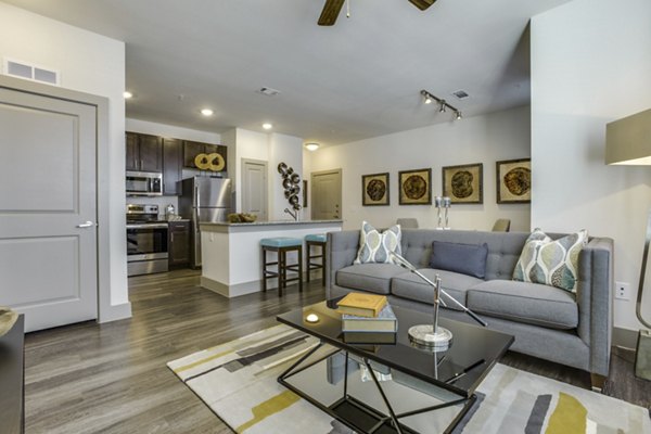 Modern living room with natural lighting and sleek furnishings at The Grayson Apartments in a luxurious Greystar community