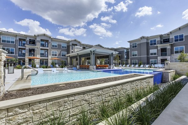 Luxury pool with lounge chairs at The Grayson Apartments, offering resort-style living and leisure facilities for residents