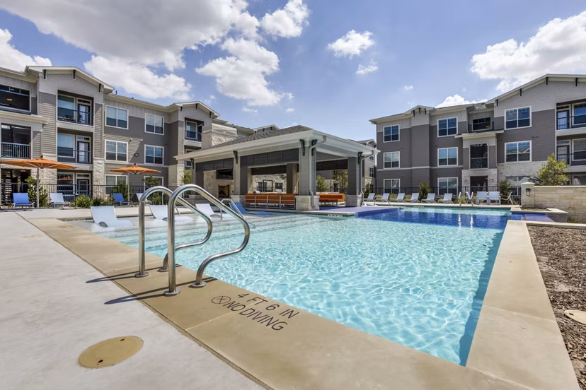 Luxurious pool at The Grayson Apartments featuring sun loungers and modern design for ultimate relaxation