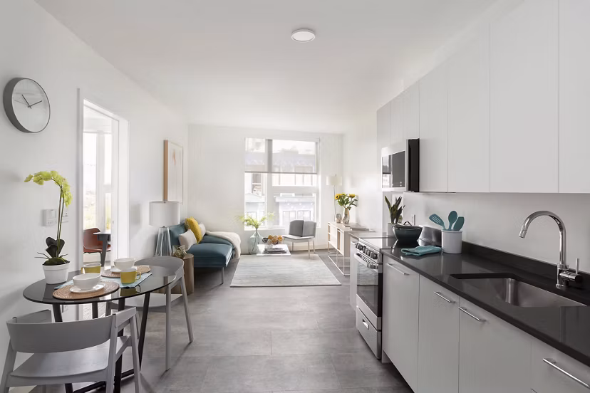 Open-concept kitchen and dining area in Watermark Central Apartments with modern fixtures and sleek design