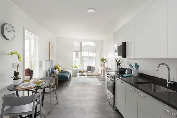 Open-concept kitchen and dining area in Watermark Central Apartments with modern fixtures and sleek design