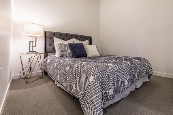 Cozy bedroom with modern decor at Pike Motorworks Apartments in luxury Seattle neighborhood