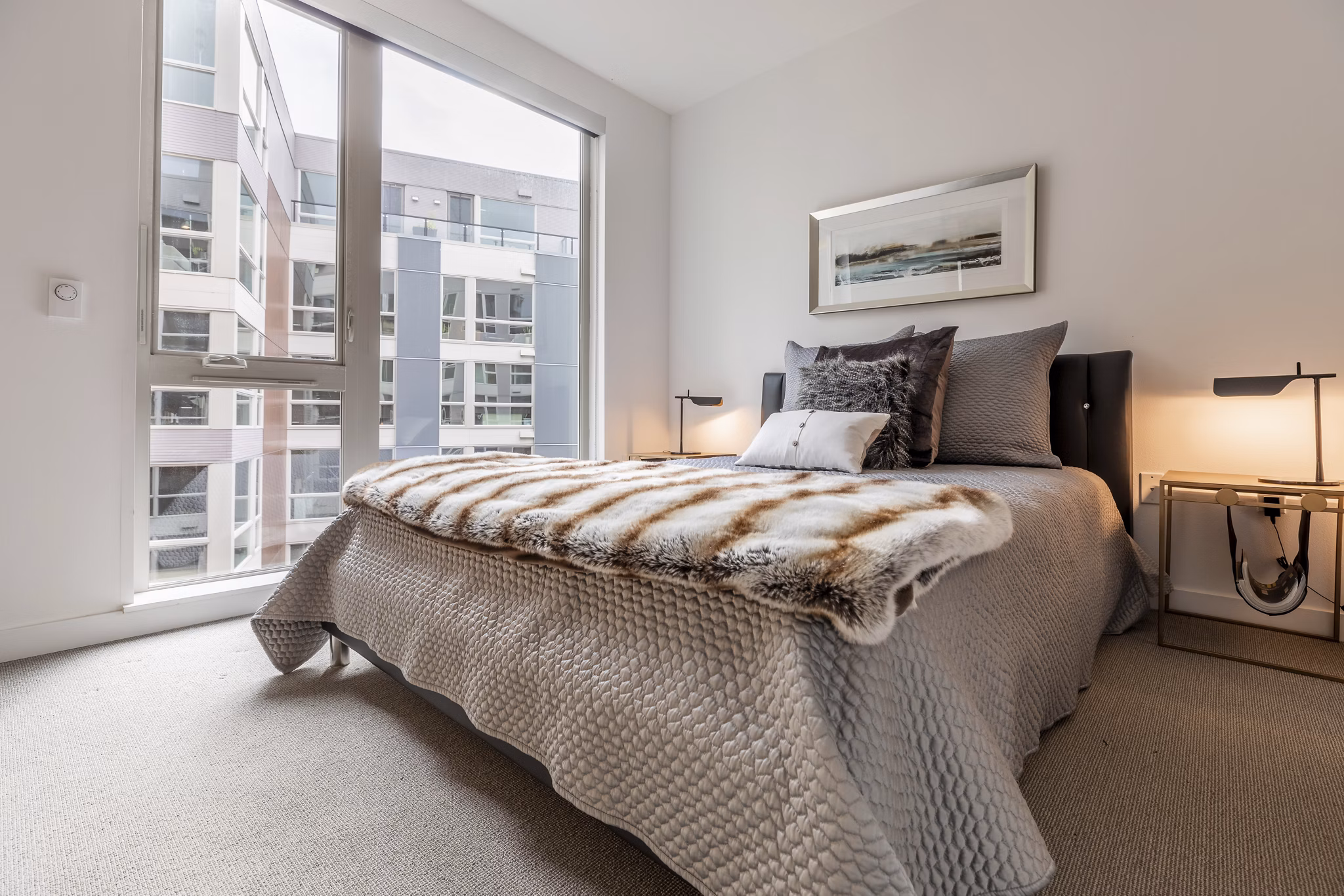 Spacious bedroom with modern decor and natural light at Pike Motorworks Apartments