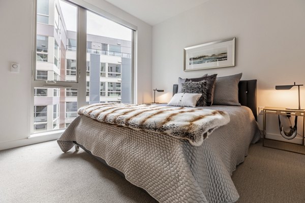 Spacious bedroom with modern decor and natural light at Pike Motorworks Apartments