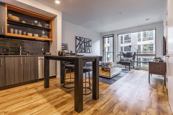 Modern kitchen with stainless steel appliances at Pike Motorworks Apartments