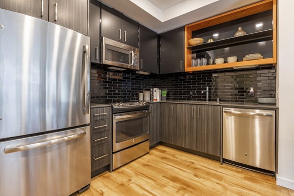 Kitchen featuring modern appliances and sleek countertops in Pike Motorworks Apartments, Seattle luxury property