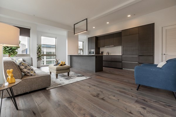 Living room with modern furnishings and large windows at Pike Motorworks Apartments, luxury living in Seattle's vibrant Capitol Hill neighborhood