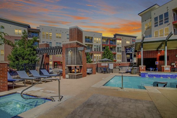 Luxurious outdoor pool at Mason at Alameda Station Apartments with sun loungers and lush greenery