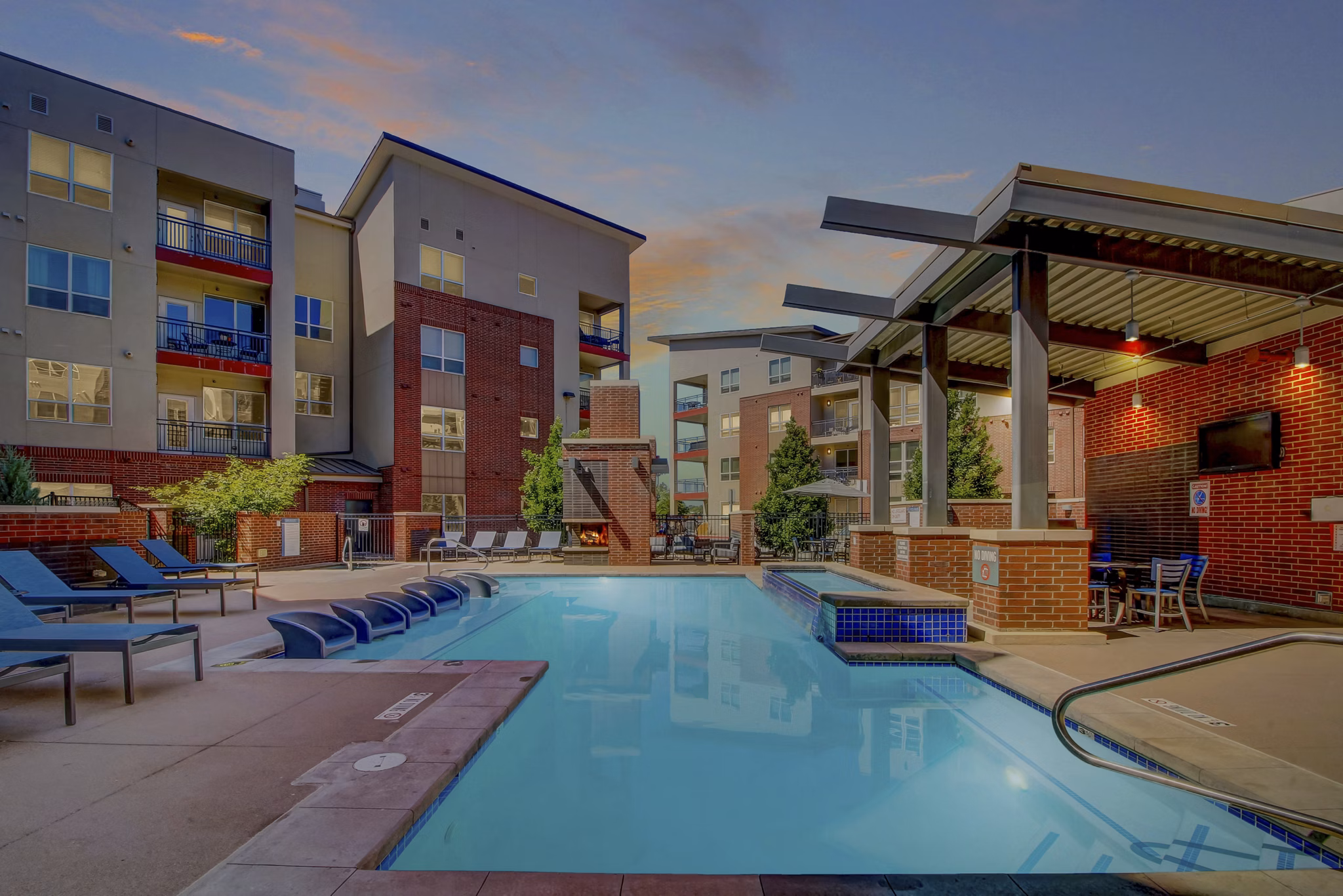 Modern outdoor pool at Mason at Alameda Station Apartments, featuring lounge chairs and umbrellas for relaxation