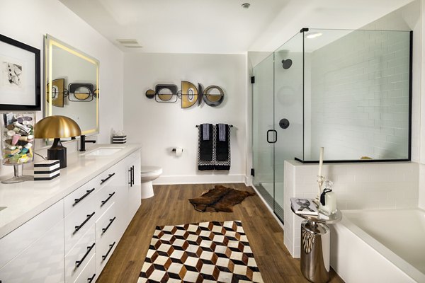 Bathroom with marble countertops and modern fixtures at Clarendon Apartments