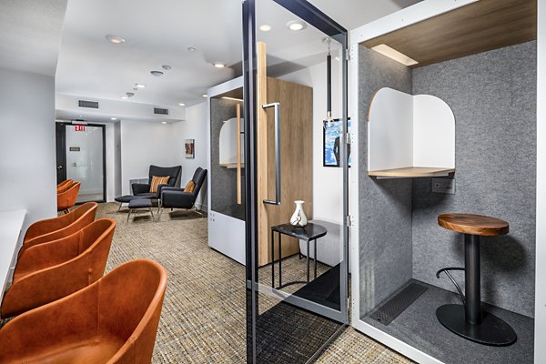 Modern business center with workstations at Clarendon Apartments, a luxury property by Greystar