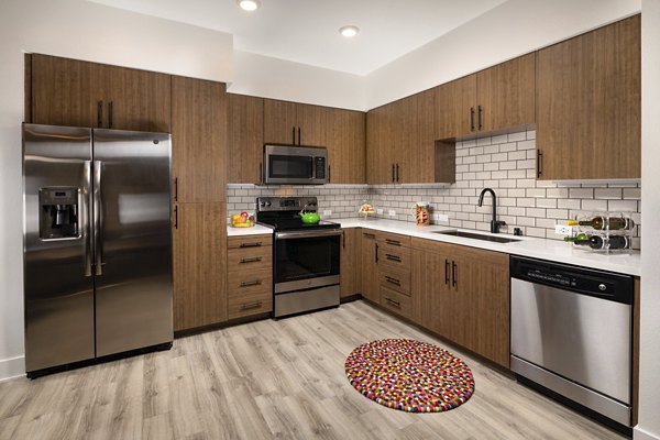 Modern kitchen featuring stainless steel appliances and granite countertops at Clarendon Apartments
