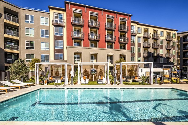 Luxurious outdoor pool at Clarendon Apartments, with modern seating and lush landscaping, perfect for relaxation in an urban oasis