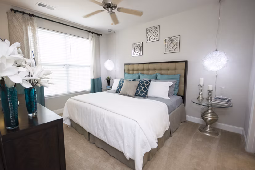 Cozy bedroom with elegant decor and large window at Tryon Place Apartments