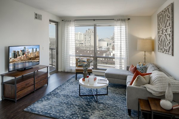 Contemporary living room with plush seating and large windows in Edgewater Apartments