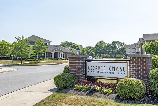 Elegant signage at Copper Chase at Stones Crossing Apartments, showcasing luxury living amidst serene surrounding landscape
